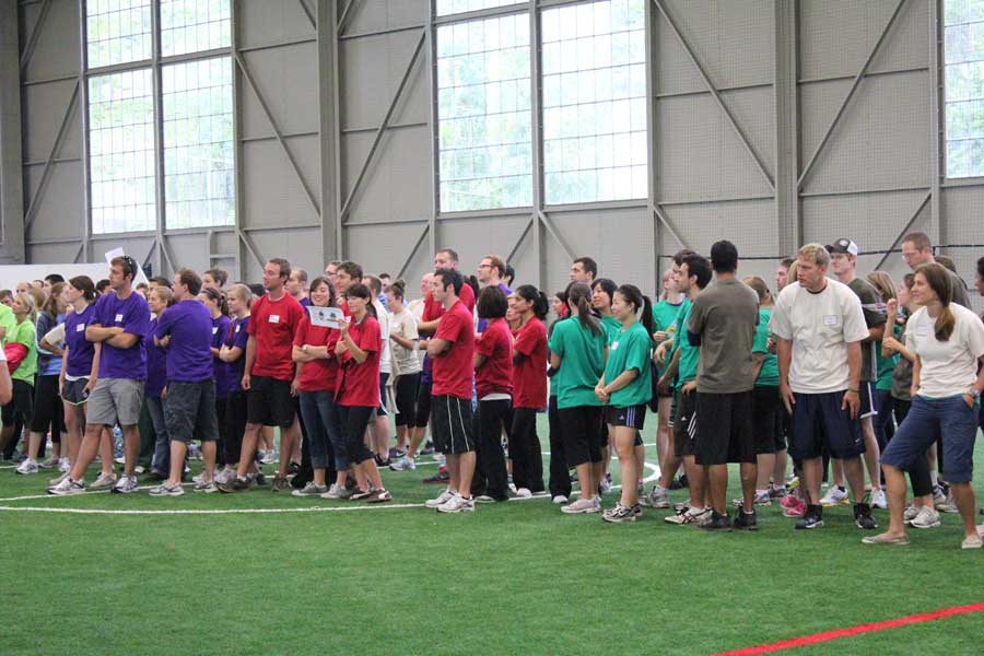 Teams in different color shirts getting ready for a group event