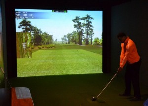 A golfer tees up a shot on the golf simulator at High Velocity Sports