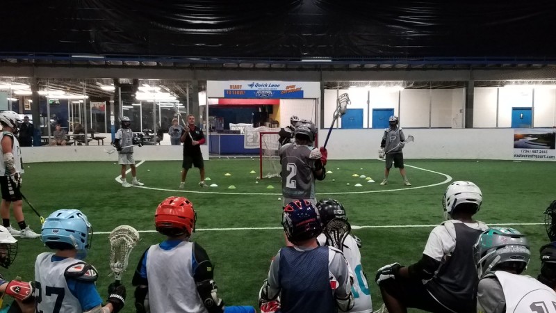 Young lacrosse goalies watch a coach demonstration in goalie school at High Velocity Sports